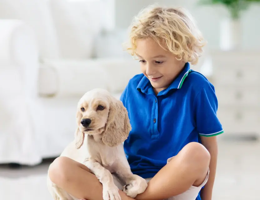 Child sitting with a happy puppy